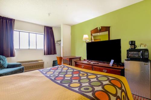 a hotel room with a bed and a flat screen tv at Super Sleep Inn in Princeton