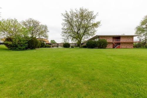 a large green yard with a house in the background at Americas Best Value Inn Rockford in Rockford