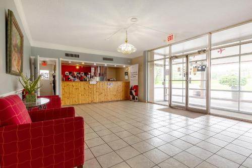 a lobby with a red couch and a restaurant at Americas Best Value Inn Rockford in Rockford