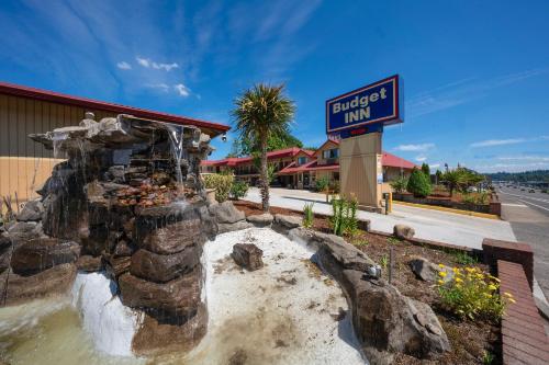 a restaurant with a water fountain in front of a building at Budget Inn Gladstone By OYO - Portland Clackamas in Gladstone