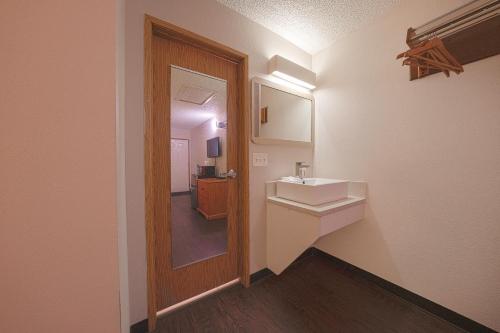 a bathroom with a sink and a mirror at Budget Inn Gladstone By OYO - Portland Clackamas in Gladstone