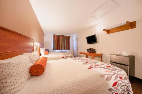 a hotel room with two beds and a television at Budget Inn Gladstone By OYO - Portland Clackamas in Gladstone