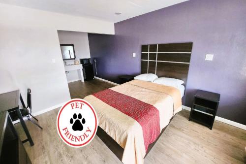 a hotel room with a bed and a sign at Travel Inn by OYO, Hwy 80 - Jackson in Jackson