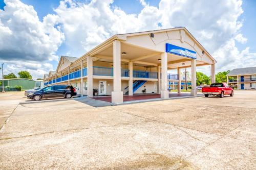 a dealership with cars parked in a parking lot at OYO Hotel Baton Rouge East I-12 Louisiana in Baton Rouge