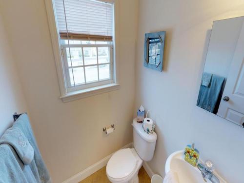 a bathroom with a toilet and a sink and a window at Roof-Top Deck With Ocean & Bay Views Single Family Beach Badges Private Yard Ping Pong And Pool Table Wifi 1 Block From Ocean 15 Blocks To Bay in Ship Bottom