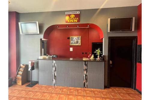 a bar in a room with a tv on the wall at La Posada Inn By OYO Brownsville in Brownsville
