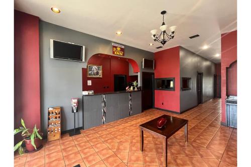 a living room with red and gray walls and a table at La Posada Inn By OYO Brownsville in Brownsville
