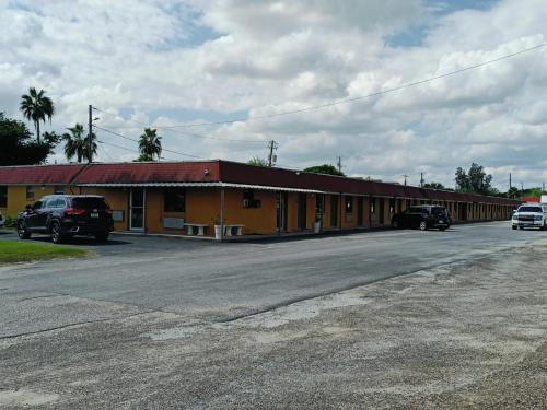 a yellow building with cars parked in a parking lot at Budget Inn By OYO Edinburg Hwy 281 in Edinburg