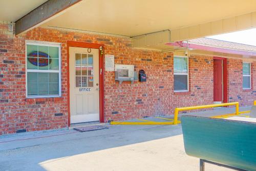 a brick building with a white door and a yellow railing at Economy Inn By OYO Lockport near Houma in Lockport