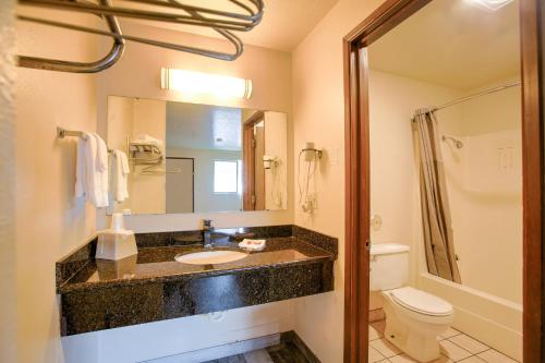 a bathroom with a sink and a toilet and a mirror at OYO Woodland Hotel and Suites in Woodland