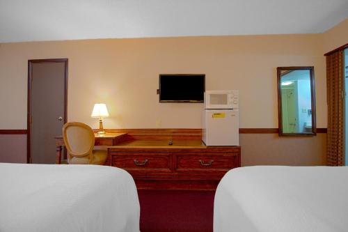 a hotel room with two beds and a television at HomeTown Inn By OYO - Liberal, KS in Liberal