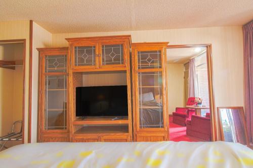 a bedroom with a entertainment center with a flat screen tv at HomeTown Inn By OYO - Liberal, KS in Liberal