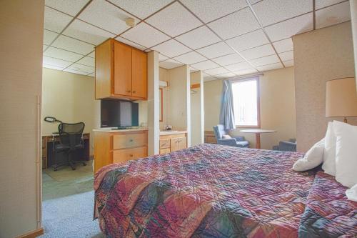 a hotel room with a bed and a desk at HomeTown Inn By OYO - Liberal, KS in Liberal