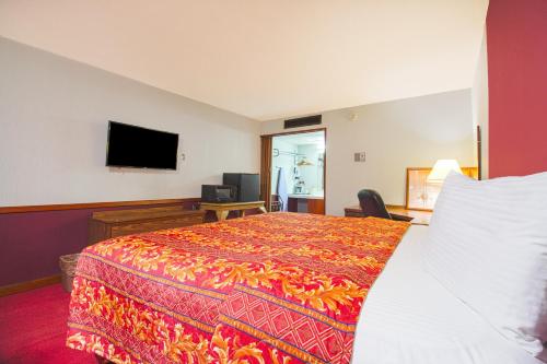 a hotel room with a bed and a flat screen tv at HomeTown Inn By OYO - Liberal, KS in Liberal