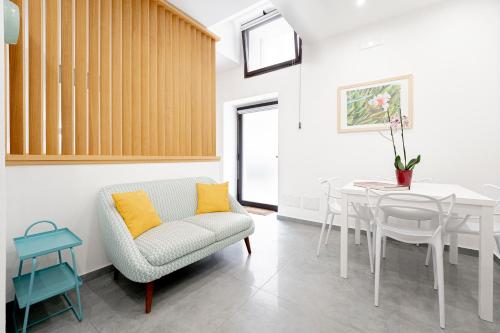 a living room with a table and a chair at Eos - Elegants Apartments & Suites in Siracusa