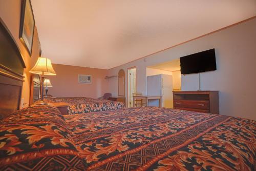 a hotel room with a bed and a flat screen tv at Monterrey Motel Padre Island, Corpus Christi BY OYO in Corpus Christi