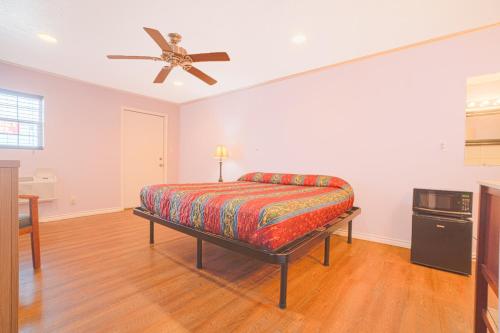 a bedroom with a bed and a ceiling fan at Monterrey Motel Padre Island, Corpus Christi BY OYO in Corpus Christi