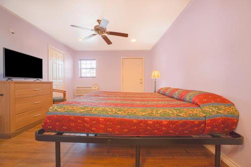 a bedroom with a bed and a ceiling fan at Monterrey Motel Padre Island, Corpus Christi BY OYO in Corpus Christi