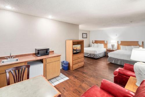 a hotel room with two beds and a living room at Inn at Lake Washington By OYO I-405 in Renton