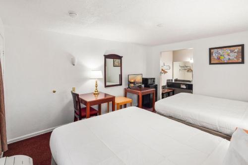 a hotel room with two beds and a desk at Inn at Lake Washington By OYO I-405 in Renton