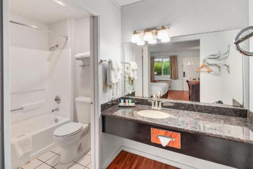 a bathroom with a sink and a toilet and a tub at Inn at Lake Washington By OYO I-405 in Renton