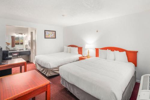 a hotel room with two beds and a desk at Inn at Lake Washington By OYO I-405 in Renton