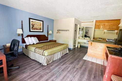 a hotel room with a bed and a bathroom at Executive Inn Ridgeway I-77 in Ridgeway
