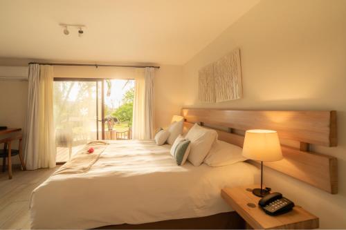 a bedroom with a large white bed and a window at Hotel Hare Uta in Hanga Roa