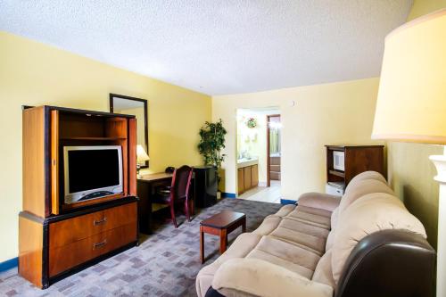 a living room with a couch and a tv at OYO Hotel Hutchinson West 4th Ave in Hutchinson