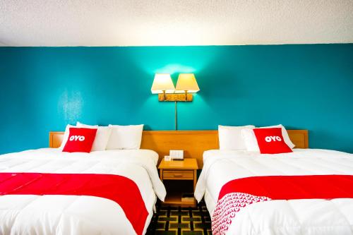 a hotel room with two beds with red and white pillows at OYO Hotel Hutchinson West 4th Ave in Hutchinson