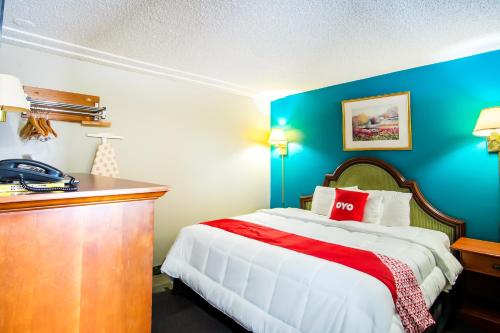 a bedroom with a large bed with blue walls at OYO Hotel Hutchinson West 4th Ave in Hutchinson