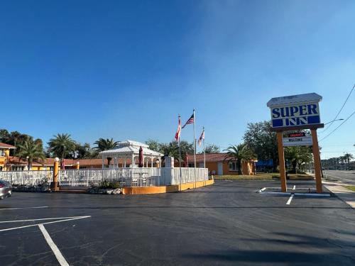 a sign for a super inn in a parking lot at Super Inn By Oyo Daytona Beach Near Airport in Daytona Beach