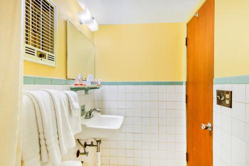 a bathroom with a sink and a mirror at OYO Hotel Downtown Peoria I-74 in Peoria