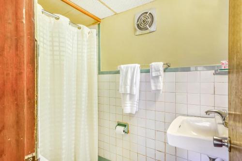 a bathroom with a shower and a sink at OYO Hotel Downtown Peoria I-74 in Peoria
