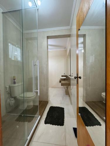 a bathroom with a glass shower and a toilet at Linda casa Serras e Águas JOANÓPOLIS in Joanópolis