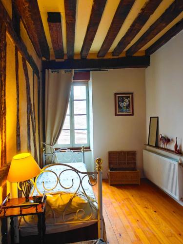 une chambre avec un lit et une table avec une lampe dans l'établissement 140m2 du XVIIe, plein centre & extérieur, 6-9 pers, à Bergerac