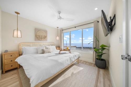 カロライナビーチにあるOcean Breeze Oasis Oceanfront Condo Pool & Elevatorの大きなベッドと窓のある寝室
