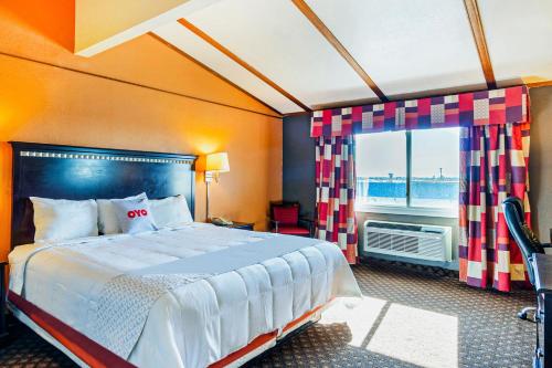 a bedroom with a large bed and a window at OYO Townhouse Dodge City KS in Dodge City