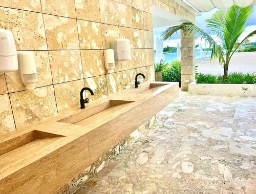 ein Badezimmer mit zwei Waschbecken an einer Steinmauer in der Unterkunft Tropical Paradise in Punta Cana in Punta Cana