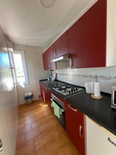 オ・ポリーニョにあるCasa Solのキッチン(赤いキャビネット、コンロ付)