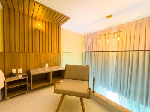 a room with a chair and a desk and a window at Star Palace Hotel Jeri in Jericoacoara