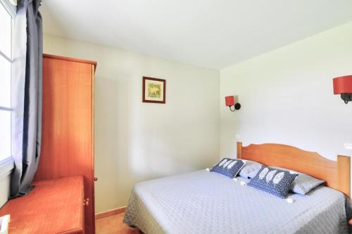 une chambre avec un lit avec des oreillers bleus dessus dans l'établissement La résidence du Lac - maeva Home - Appartement 2 pièces 5 personnes - Sélection MAE-4111, à Monflanquin