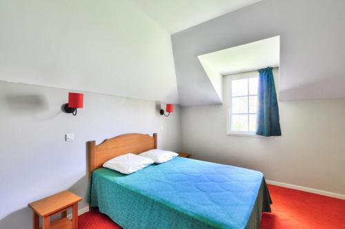 une chambre avec un lit bleu et une fenêtre dans l'établissement La résidence du Lac - maeva Home - Appartement 2 pièces 5 personnes - Sélection MAE-7651, à Monflanquin
