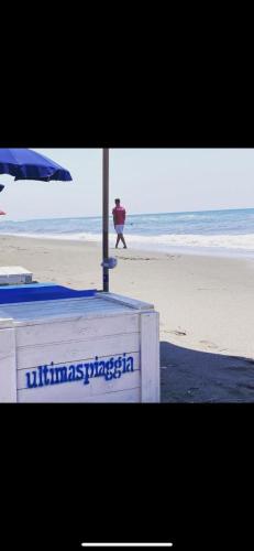 a man walking on the beach with an umbrella at Villa Enli in Capalbio