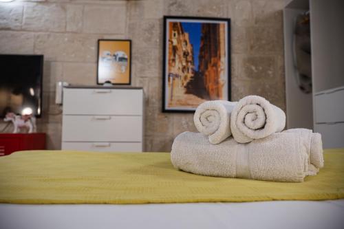 a room with two rolled towels on a bed at Casa San Carlo in Valletta
