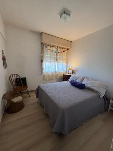 a bedroom with a bed and a chair and a window at Departamento La Rotonda in Santa Rosa