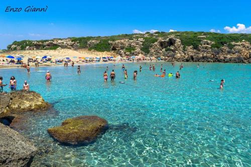 a group of people in the water at a beach at Candiano Palace in Portopalo
