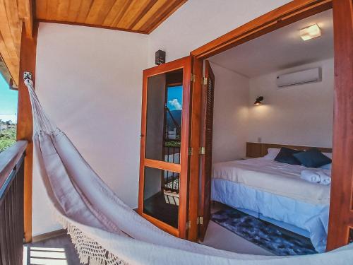 a hammock in a room with a bed at Pousada Mirante do Sol in Paraty