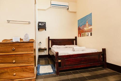 グラナダにあるCasa PUREのベッドとドレッサーのある小さな寝室