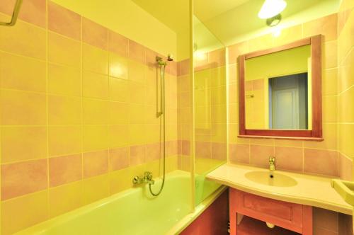 une salle de bain avec un lavabo, une baignoire et un miroir dans l'établissement La résidence du Lac - maeva Home - Appartement 2 pièces 4 personnes - Sélection MAE-5911, à Monflanquin